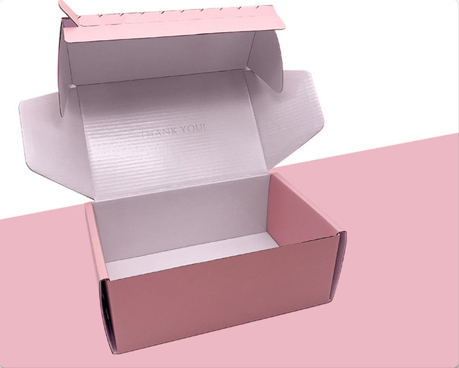 Boîtes cadeaux en carton ondulé rose avec ruban adhésif déchirant